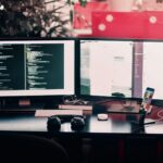 two black computer monitors on black table